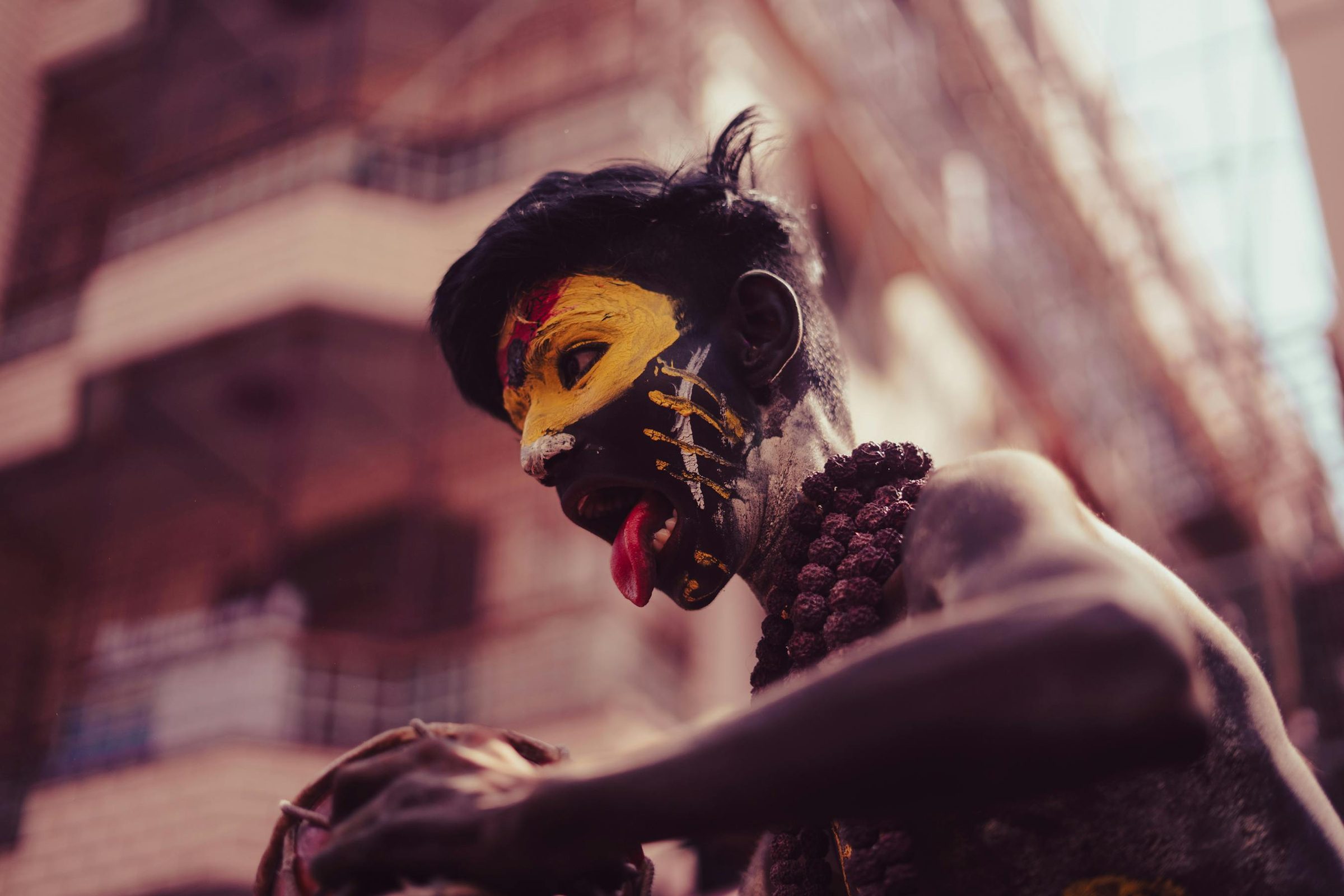 Profile of a sadhu with yellow and red face paint and rudraksha beads